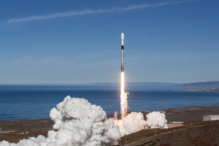 A rocket blasting off from a coastal launch site.