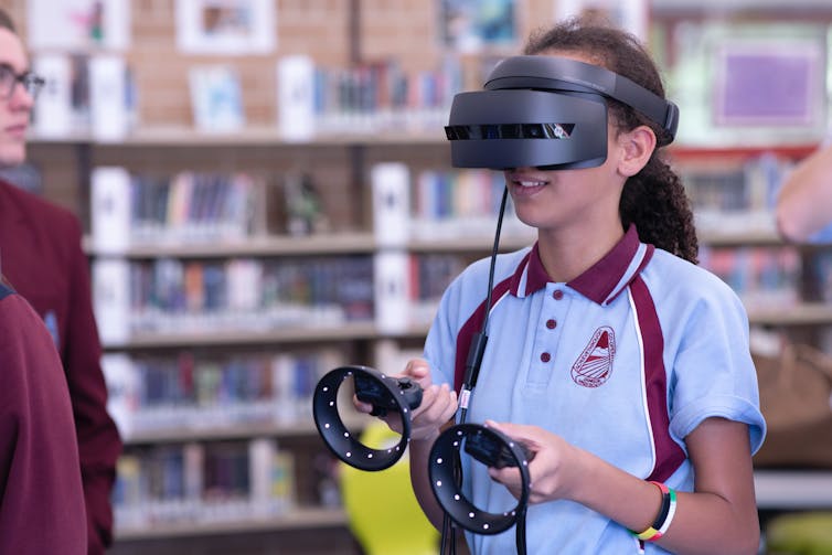 Person wearing extended reality headset in a library.