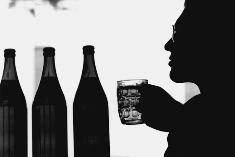  man holding glass next to bottles