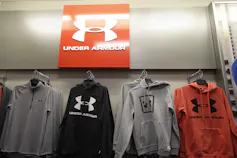 Under Armour hoodies hang on a rack.