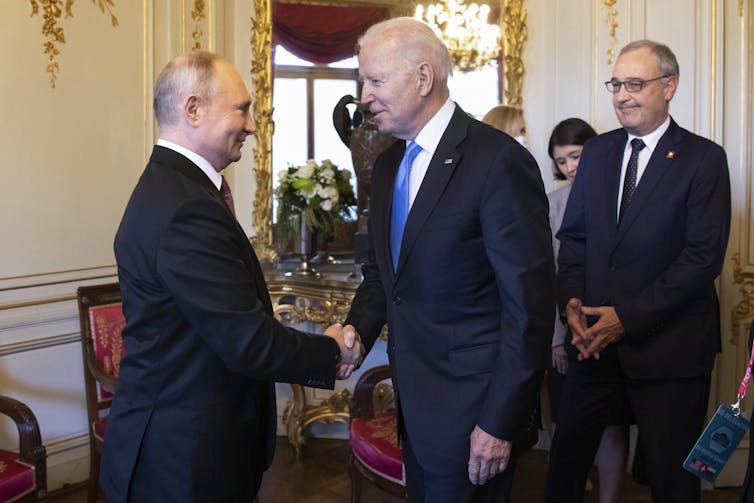 Vladimir Putin shaking hands with Joe Biden