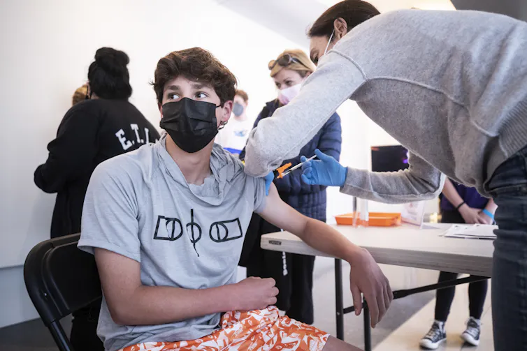 A 14 year old receiving a COVID-19 vaccine in California, USA