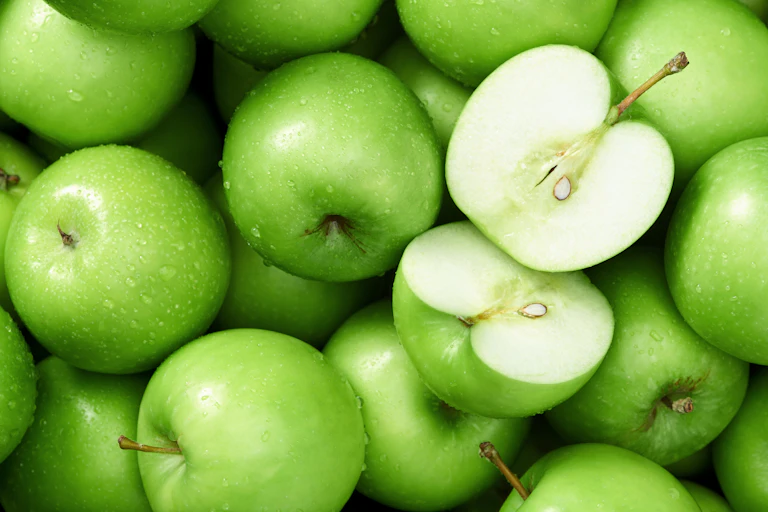 Green apples with one cut open.
