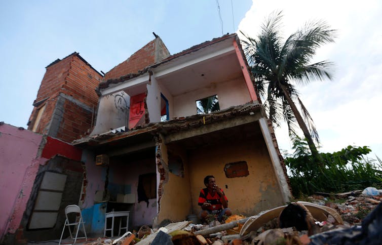 Luis Geraldo, 52, smokes a cigarette in the rubble of his home after much of the Vila Autodromo favela was demolished to make way for the Rio 2016 Olympic Park