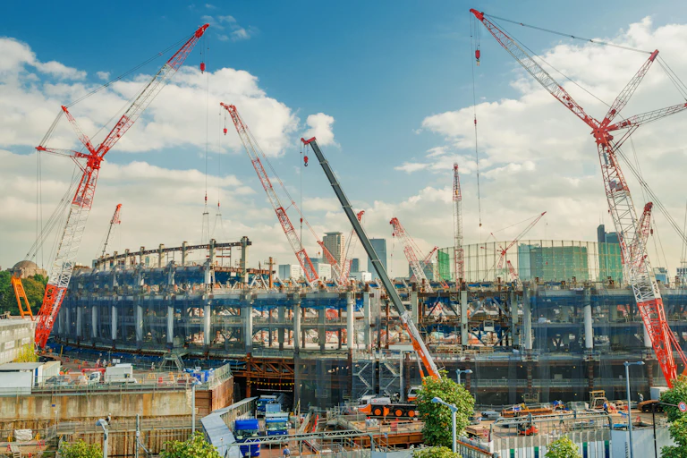 Cranes tower over a partially built stadium