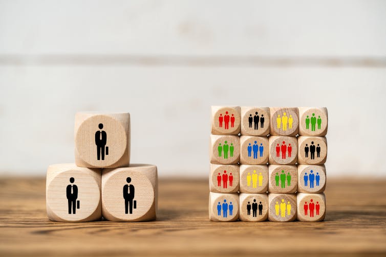 Wooden blocks representing big companies and small companies