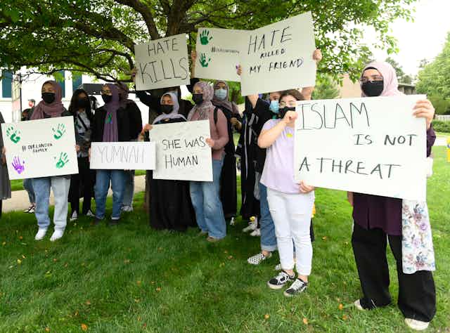 High school students hold up signs protesting against anti-Muslim hate.