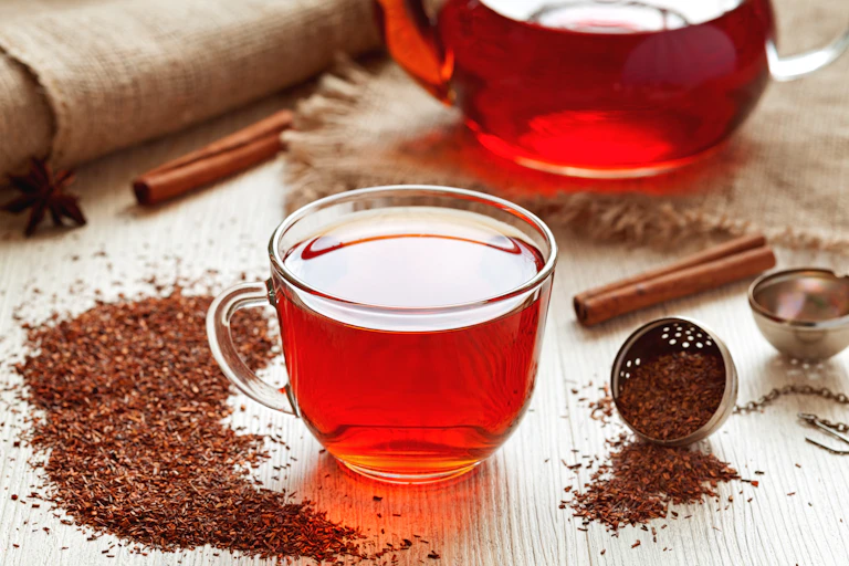 Una taza de cristal con infusión de rooibos