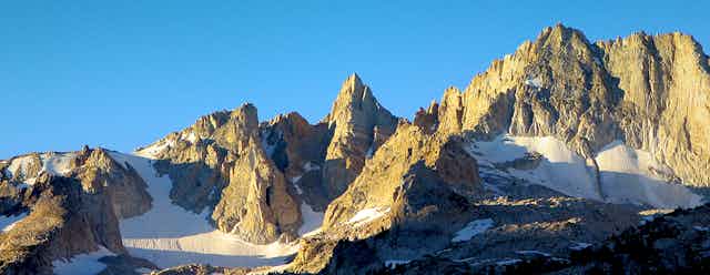 A high mountain peak with snow at the base.
