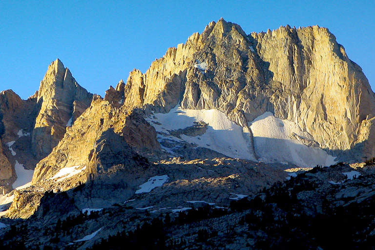 A high mountain peak with snow at the base.