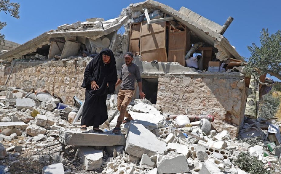 Deux habitants marchent sur les décombres d'une maison, après un bombardement des troupes du régime, à Serja dans la province d'Idlib, le 17 juillet dernier.