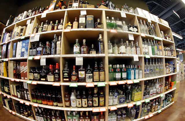Many shelves of alcoholic beverages in a store.