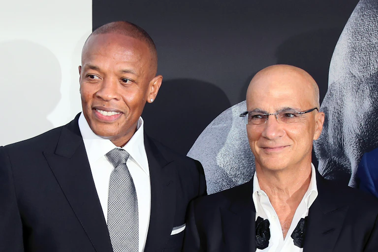 Two men stand next to each other smiling.