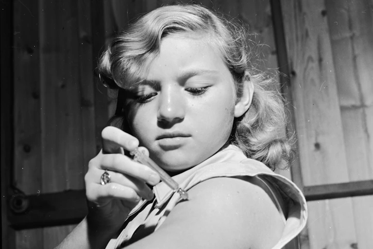 girl injecting insulin into her upper arm