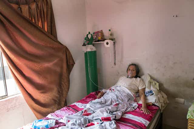 Woman with COVID-19 using oxygen tank in her home in Lima, Peru