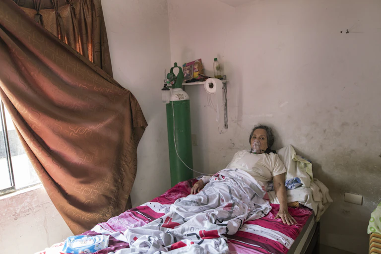 Woman with COVID-19 using oxygen tank in her home in Lima, Peru