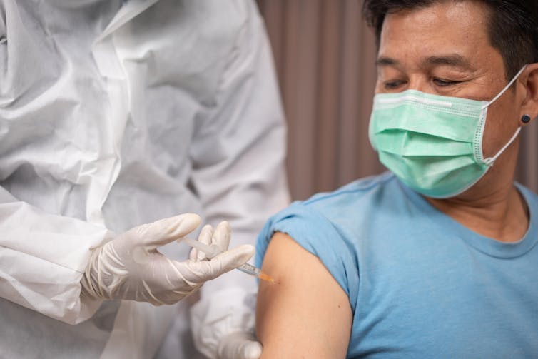 Paciente do sexo masculino sendo vacinado.