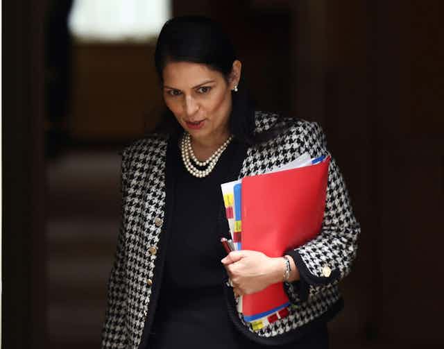 Home secretary Priti Patel carrying folders under her arm.
