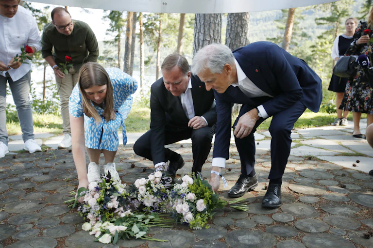 Leader of AUF in Norway, Astrid Hoem, Prime Minister of Sweden Stefan Loefven and leader of the Norwegian Labor Party Jonas Gahr Store lay flowers at a memorial for the victims of the Utoya massacre.