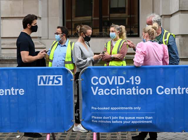 People queuing outside of a UK COVID vaccine centre