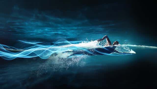 Person swimming, leaving streaks of light in path