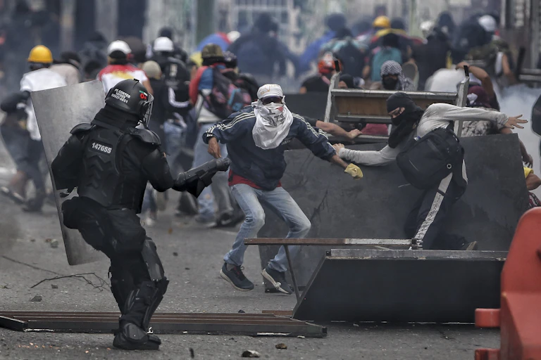 Altercation entre des policiers et manifestants dans la rue.