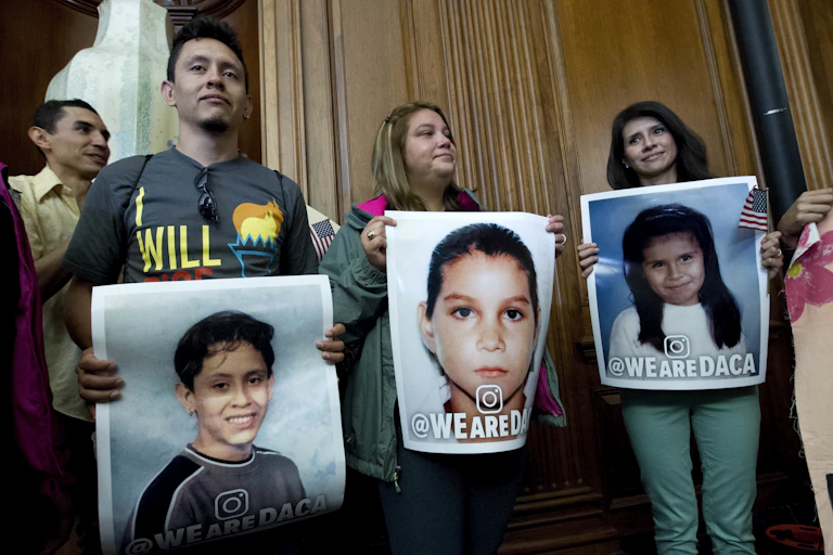 Three adults hold pictures of themselves as children