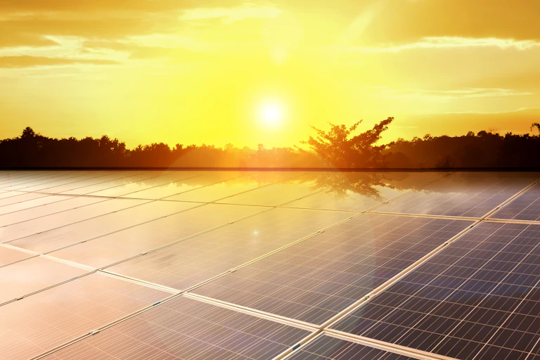 Solar panels with Sun shining in the sky