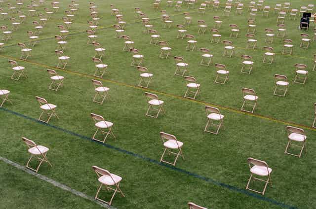 Socially distanced chairs fill a field.