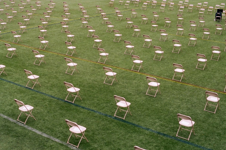 Socially distanced chairs fill a field.