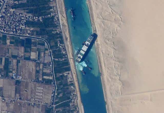 A birds-eye view of a large carrier ship blocking the Suez Canal