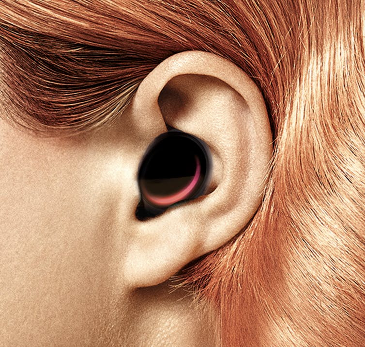 A close-up of a person's ear including a listening device