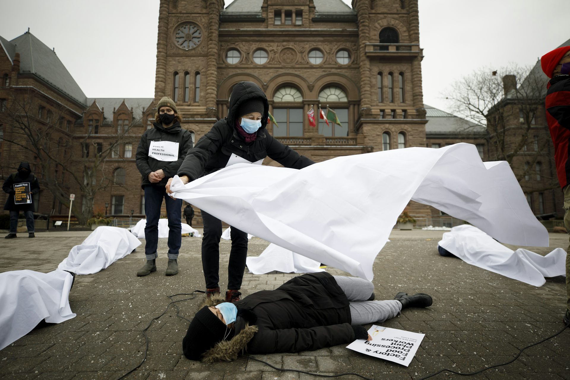 A demonstrator covers a person with a sheet.