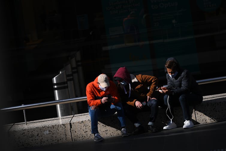 Young Australians looking at their phones.