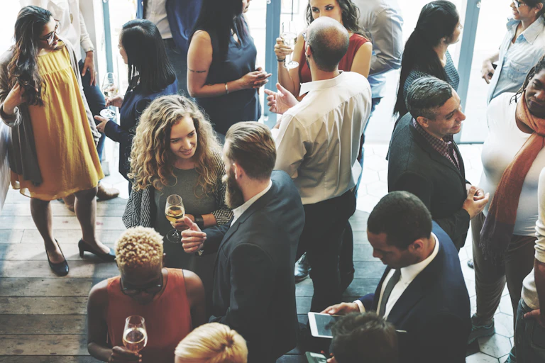 A group of people mingling with drinks.