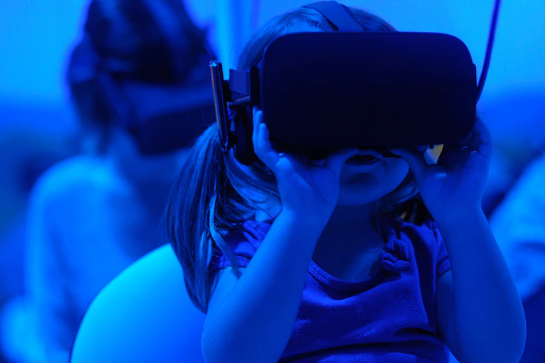 Photos d’enfants portant des casques de réalité virtuelle, dans une ambiance bleutée.