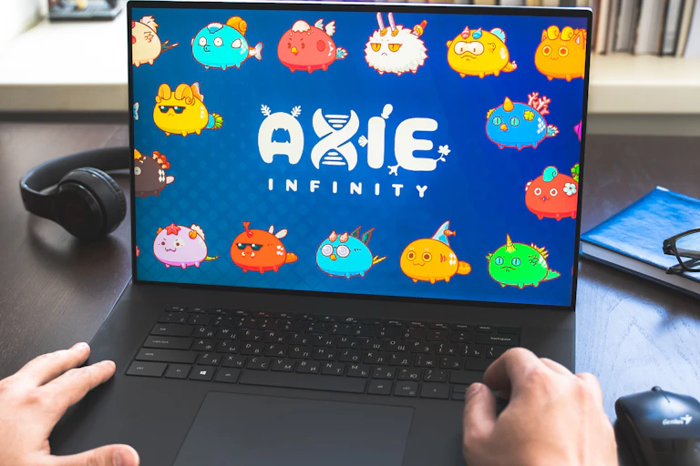 A laptop showing Axie Infinity with someone's hands on the keyboard
