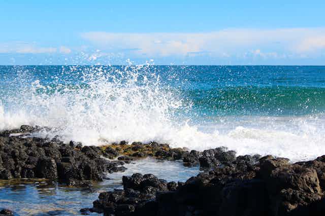 White sea spray as waves crash into rock pool.