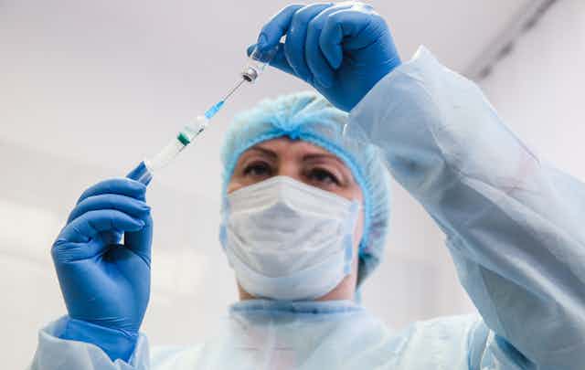 A Ukrainian nurse fills a syringe with the CoronaVac vaccine