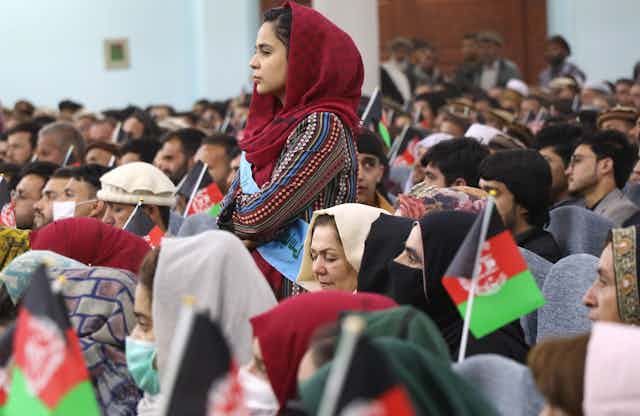 Afghan women, youths, activists and elders gather at a rally to support peace talks and the republic government in Kabul, Afghanistan. One woman is standing up.