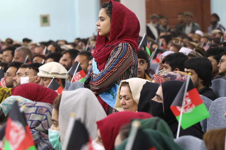 Afghan women, youths, activists and elders gather at a rally to support peace talks and the republic government in Kabul, Afghanistan. One woman is standing up.