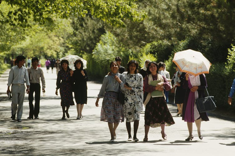 Young men and women stroll in Kabul park.