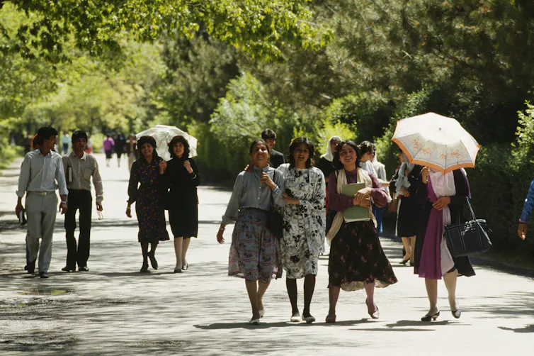 De jeunes hommes et femmes marchent dans un parc de Kaboul