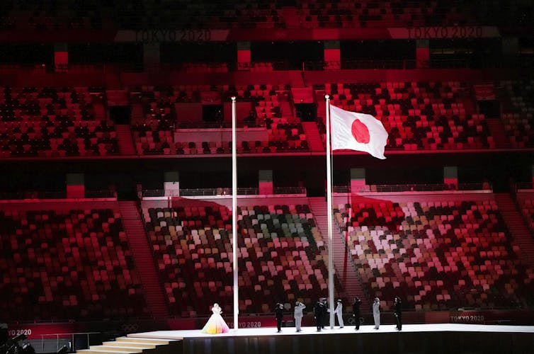 The flag is raised in-front of empty seats.