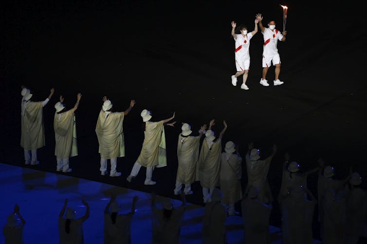 Two people carry the torch.
