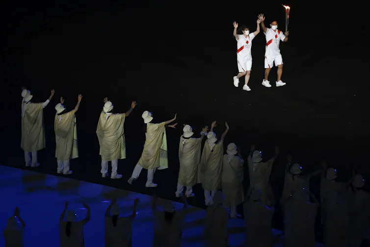 Two people carry the torch.