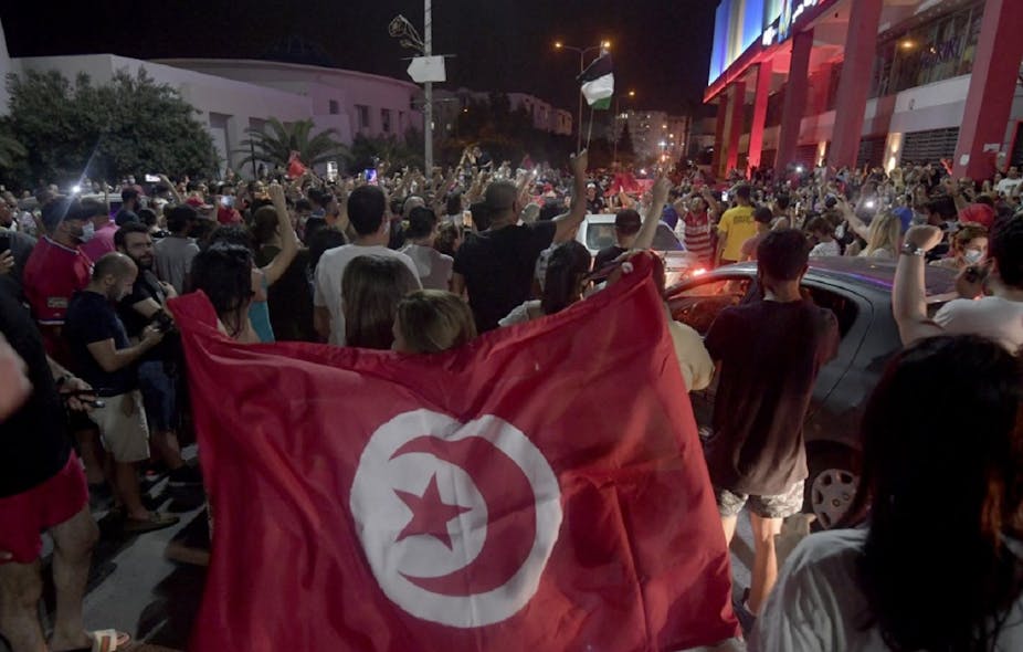 Des manifestants défilent en liesse dans les rues de Tunis après l'allocution du président Kaïs Saïed annonçant le gel des travaux de l'Assemblée et le limogeage du Premier ministre, le 25 juillet 2021.