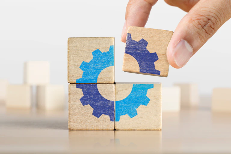 A hand places a missing square in a box, like a puzzle piece