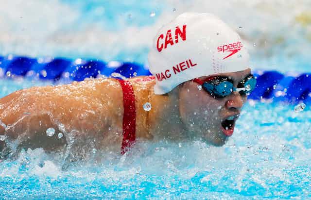 Margaret Mac Neil is shown with her mouth open as she completes a butterfly stroke.