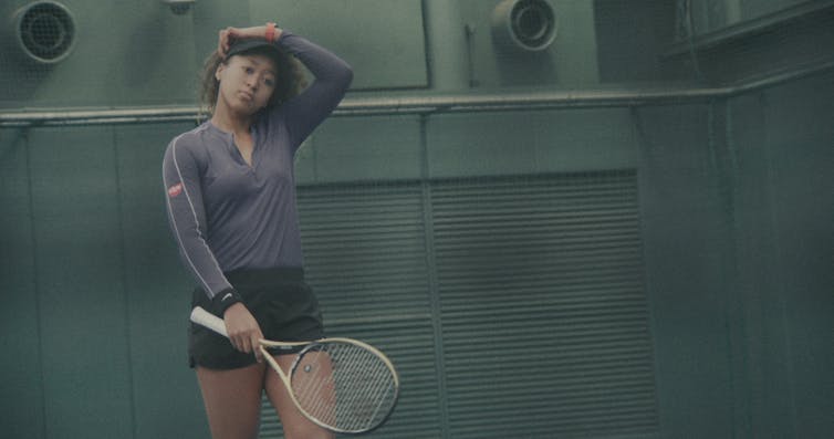Osaka holding a tennis racquet.